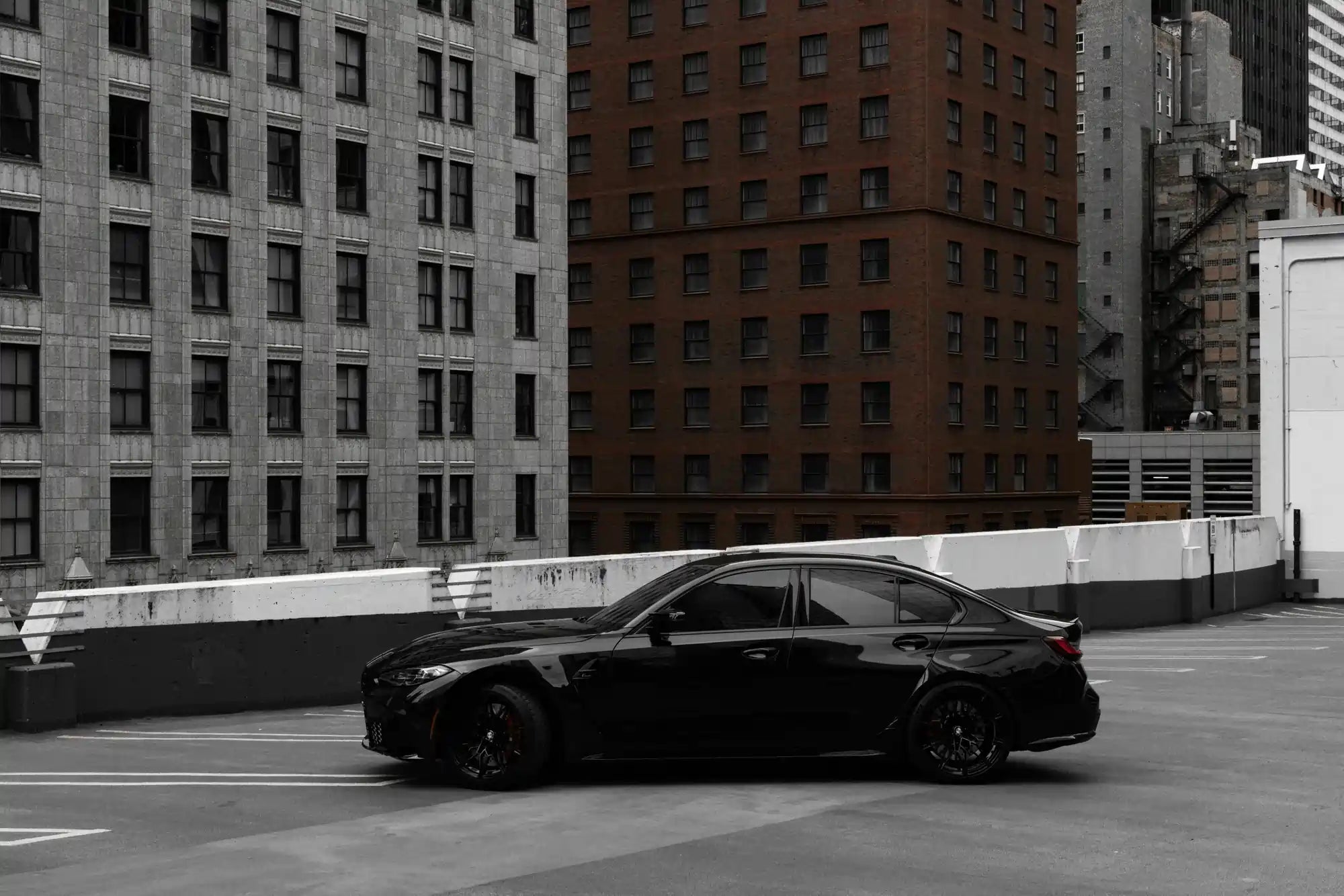 Black BMW 3 Series driving scene in modern city environment, premium automotive styling