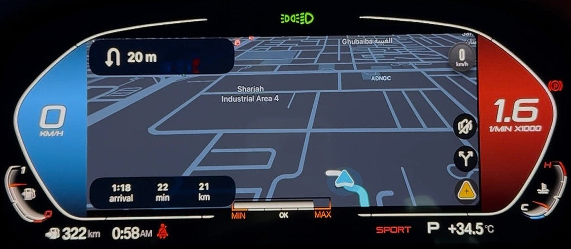 A close-up of a BMW's digital instrument cluster display showing a navigation map, speed of 1.6, and vehicle status, set against a dark interior background.