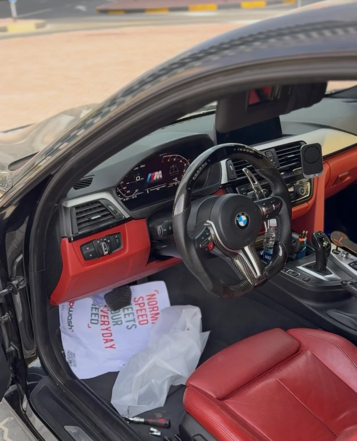 BMW digital cluster retrofit shown in a customized interior with steering wheel, dashboard and center console