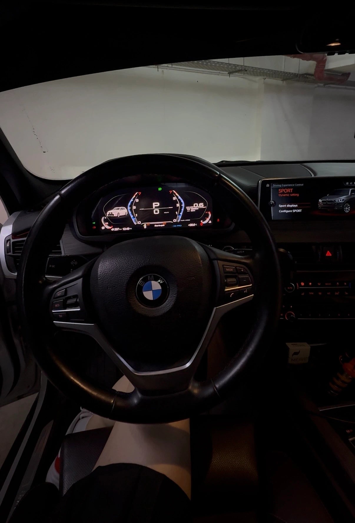BMW digital instrument cluster installed in the cockpit with steering wheel and factory infotainment display