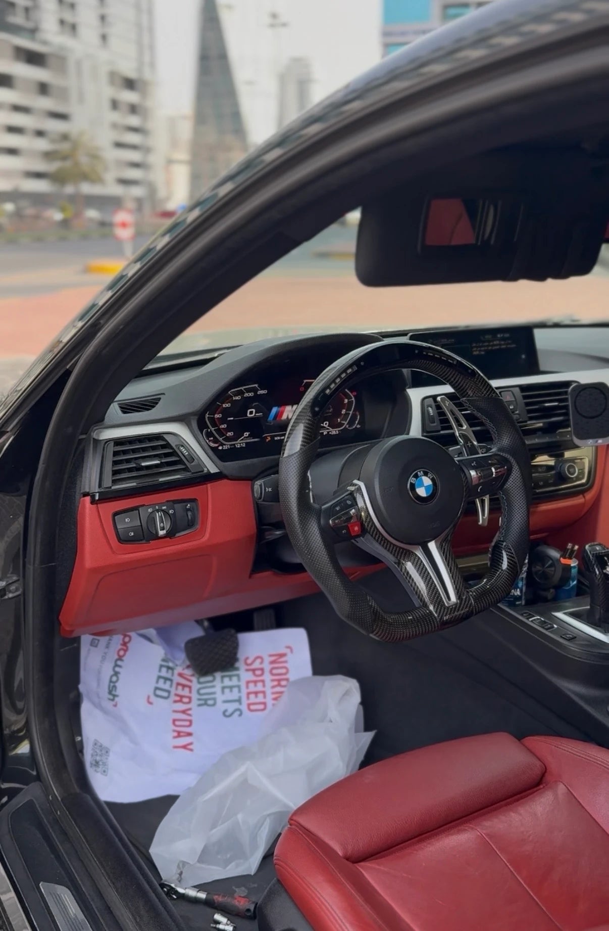 BMW digital instrument cluster installed in a customized interior with steering wheel, dashboard and factory infotainment screen