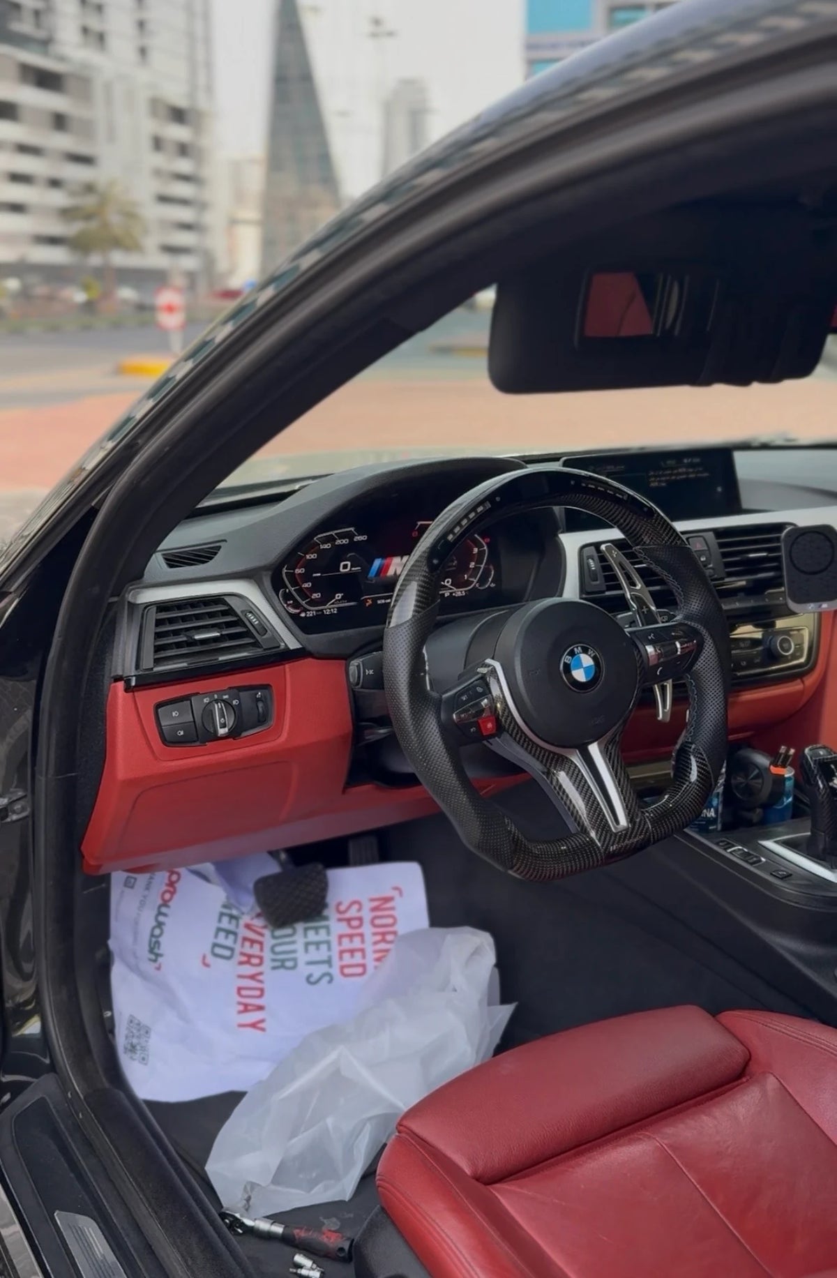 BMW digital instrument cluster installed in a customized interior with steering wheel, dashboard and factory infotainment screen