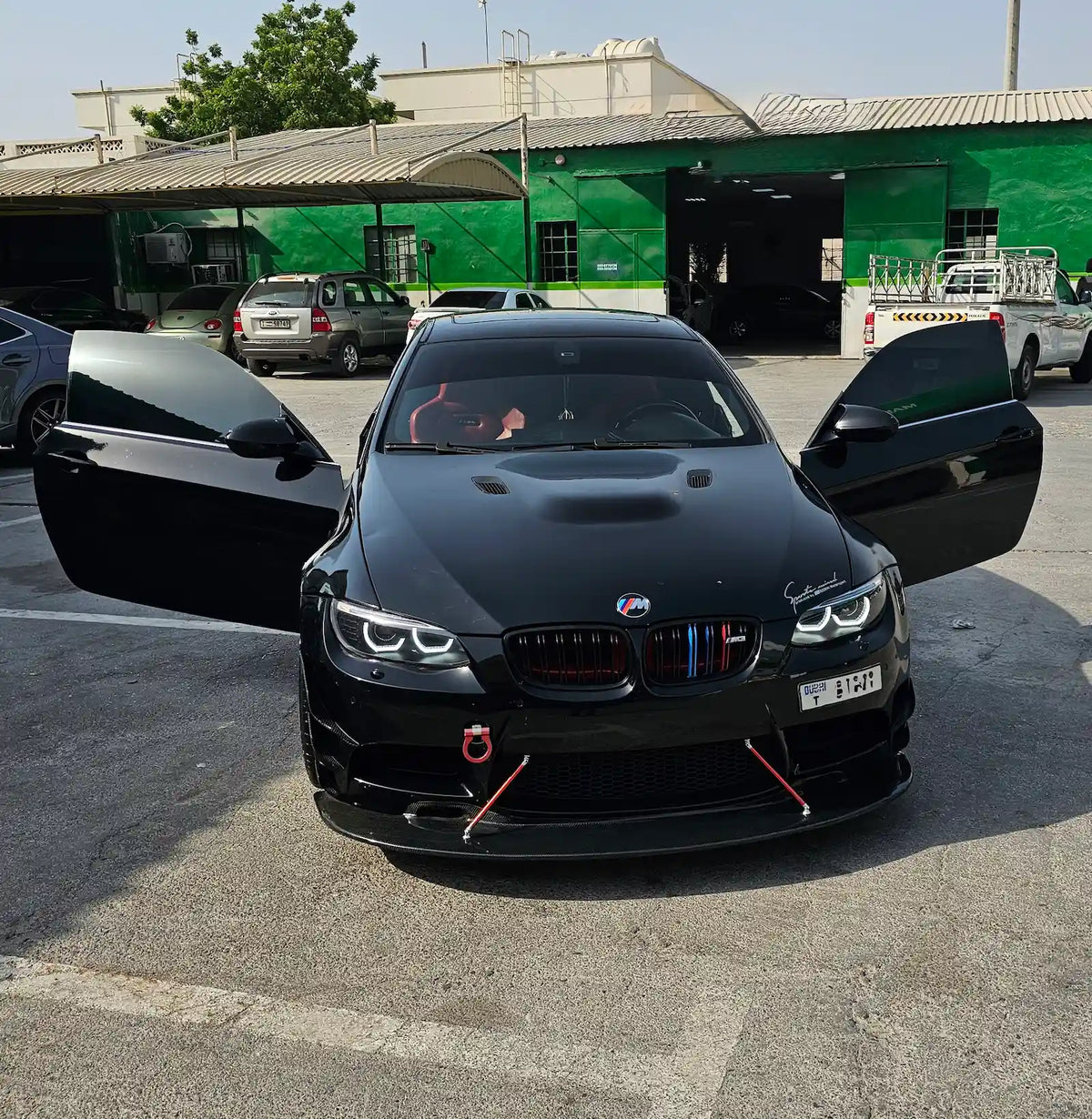 BMW E92 with illuminated animated LED halo headlights, photographed from the front with both doors open.