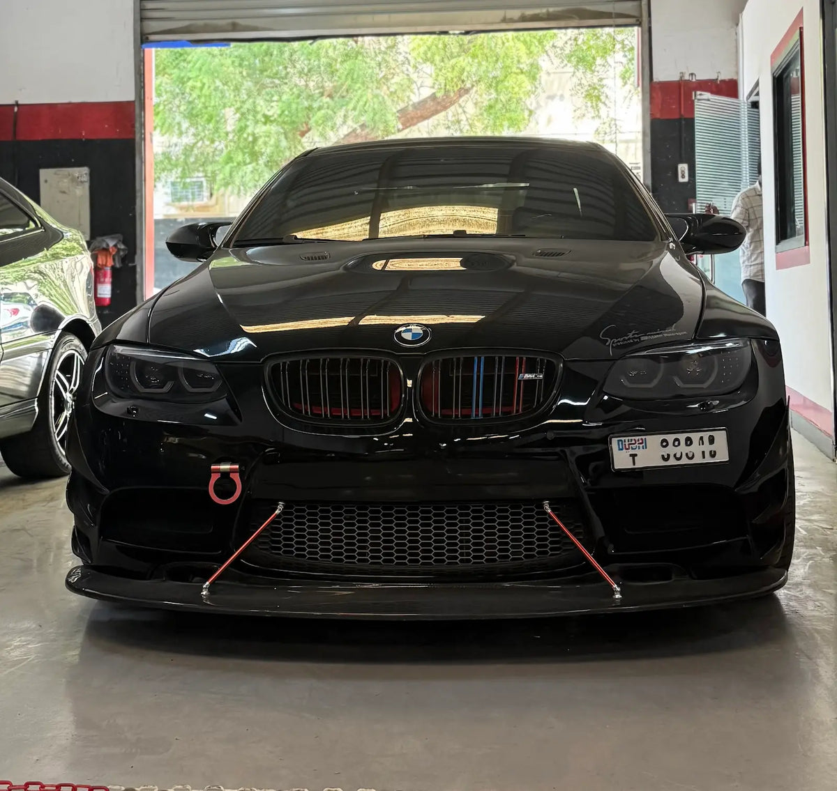 BMW E92 with black housing LED headlights installed, shown from the front in a real-life vehicle installation.