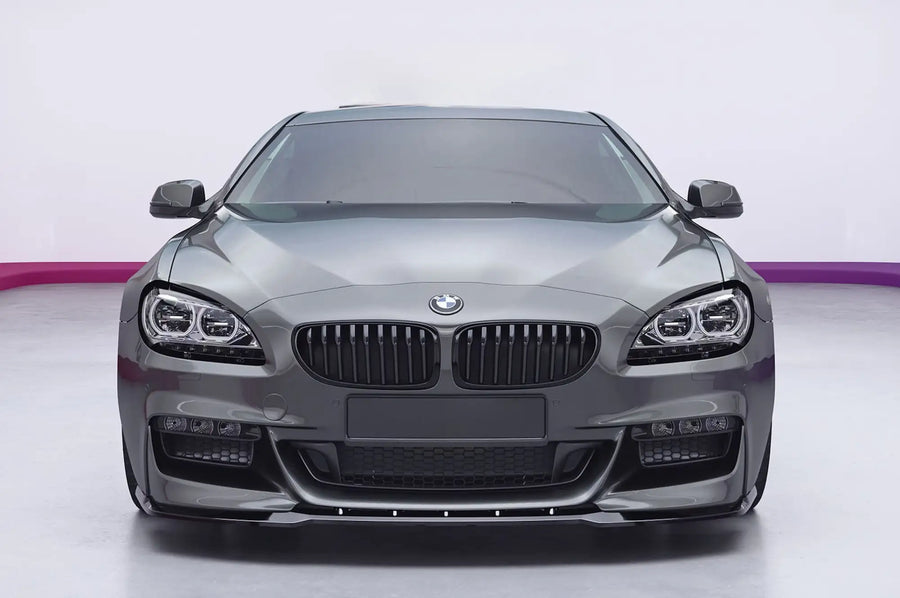 A front-facing view of a dark gray BMW 6 Series coupe with aftermarket front bumper and lower grille modifications, set against a white studio background with a purple accent line.