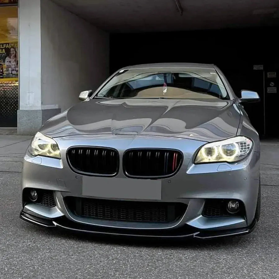 Gray BMW f10 car parked in a garage with the headlights on