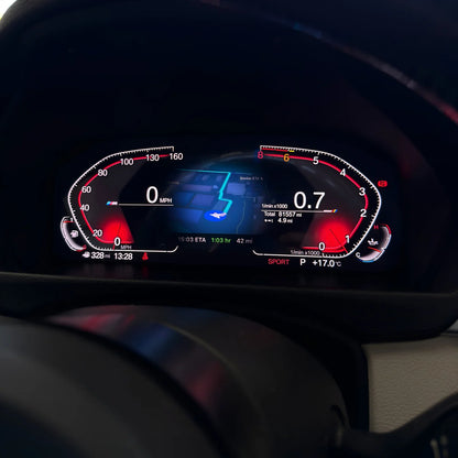 A close-up of a BMW's digital instrument cluster display showing a dark dashboard interface with red, white, and blue illuminated graphics and speedometer/tachometer markings and maps.