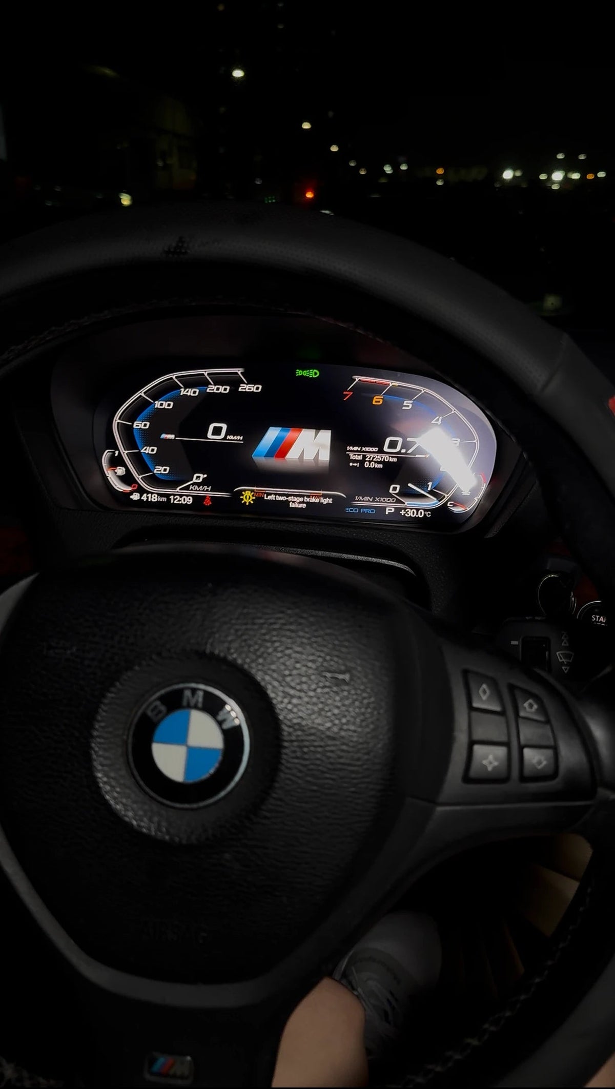 BMW X5 E70 with a modern digital instrument cluster installed and illuminated during night driving