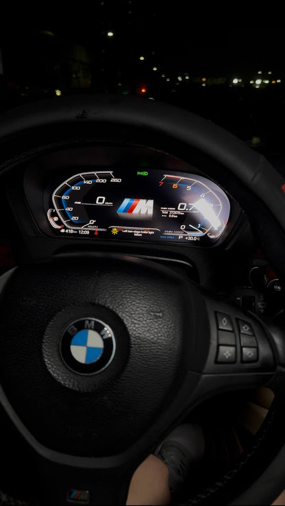 BMW X5 E70 with a modern digital instrument cluster installed and illuminated during night driving