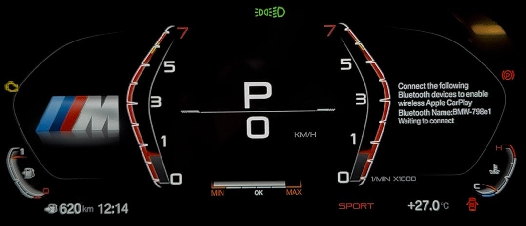 A close-up of a BMW's digital instrument cluster display, showing a black screen with red and white gauges, a central 'P O' indicator, and a BMW M logo on the left side.