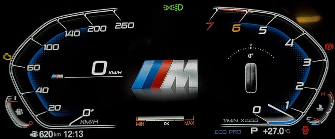 A bmw digital instrument cluster display showing a BMW M-themed dashboard screen on a black background, with illuminated speedometer, tachometer, and center M logo.